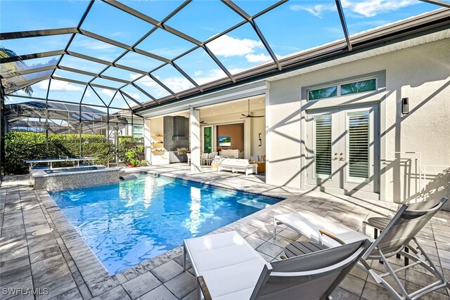 view of pool featuring an in ground hot tub, ceiling fan, a patio, and glass enclosure