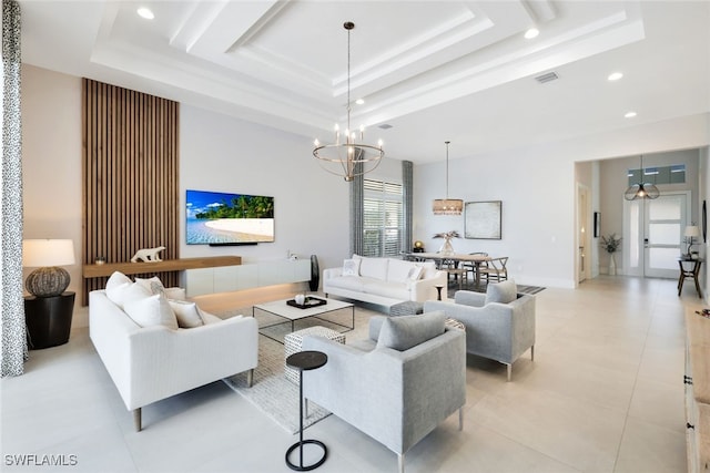 living room featuring a tray ceiling, light tile patterned floors, and a notable chandelier