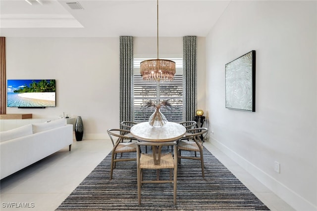 tiled dining room featuring an inviting chandelier