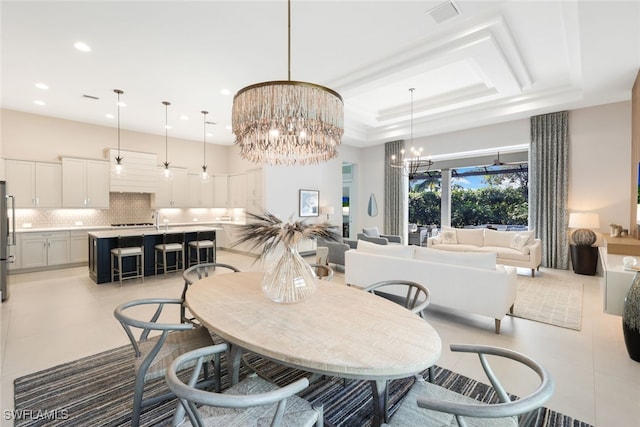 tiled dining room with a notable chandelier, a tray ceiling, and a towering ceiling