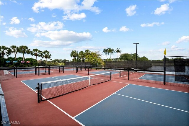 view of tennis court with a water view