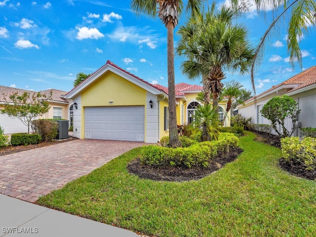 view of front of property with central AC, a front lawn, and a garage