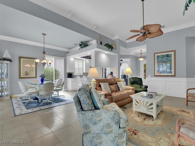 living room featuring light tile patterned floors, ceiling fan with notable chandelier, and ornamental molding