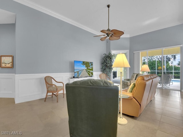 living room with ceiling fan, light tile patterned floors, a high ceiling, and ornamental molding