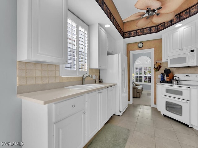 kitchen featuring sink, white cabinets, a healthy amount of sunlight, and white appliances