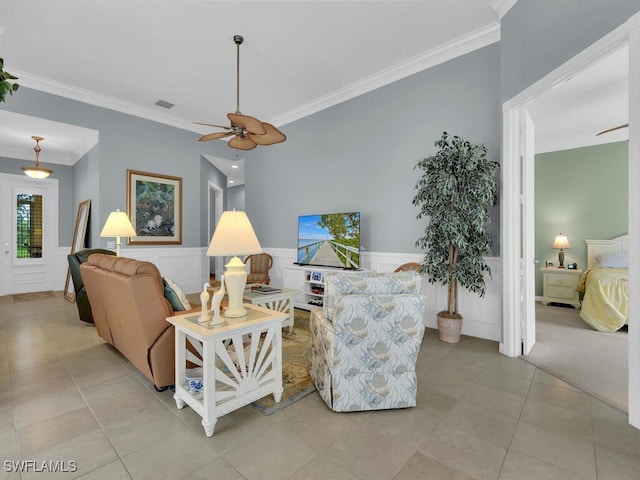 tiled living room with crown molding and ceiling fan