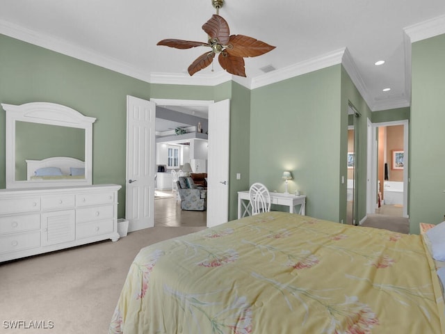 carpeted bedroom with ceiling fan, ornamental molding, and ensuite bathroom