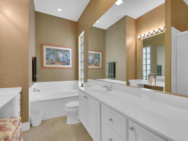 bathroom with toilet, vanity, a tub to relax in, and tile patterned floors