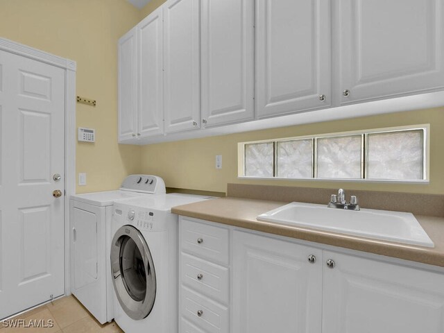 laundry area with cabinets, separate washer and dryer, a wealth of natural light, and sink