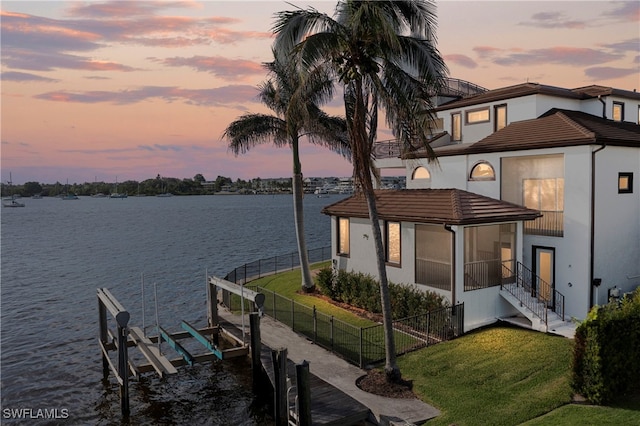 dock area with a yard and a water view