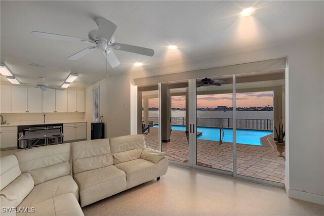 living room with a water view and ceiling fan