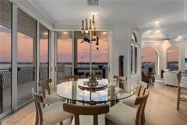 dining area with ceiling fan, light wood-type flooring, and crown molding