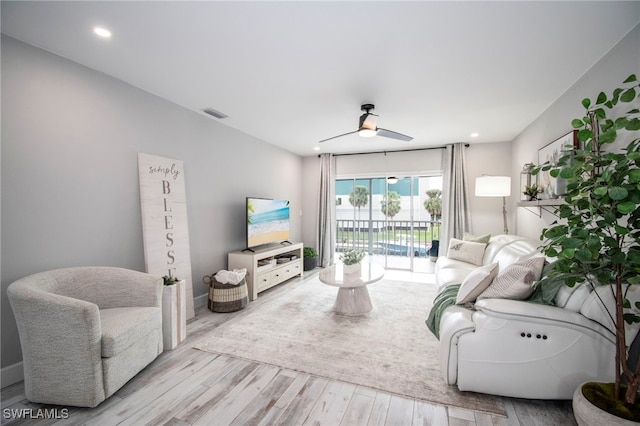 living room with ceiling fan and light wood-type flooring