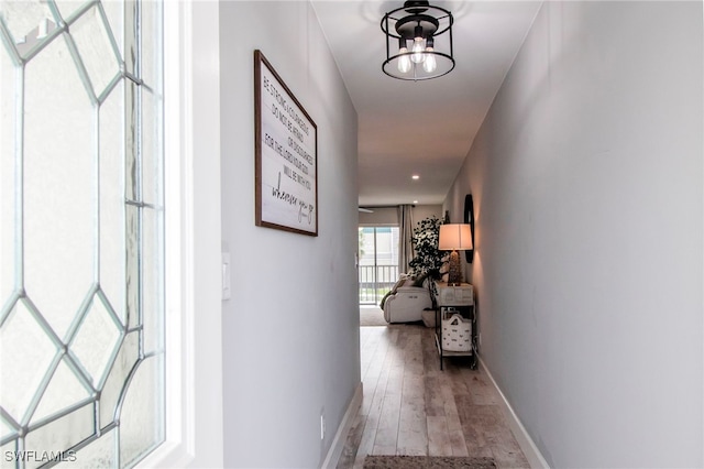 corridor featuring a chandelier and light hardwood / wood-style flooring