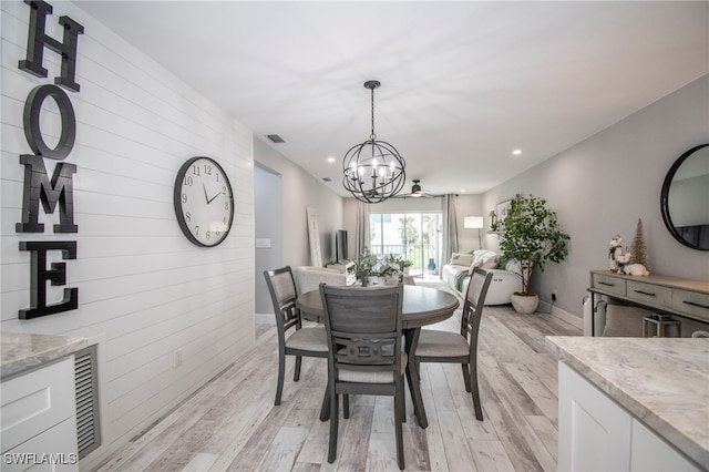 dining space featuring light hardwood / wood-style floors and a chandelier