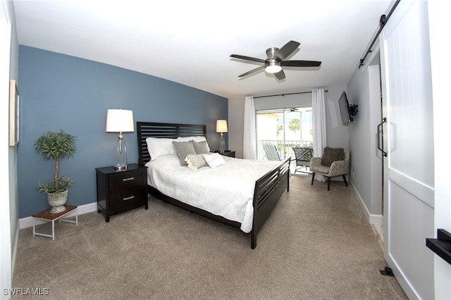 carpeted bedroom with ceiling fan and a barn door