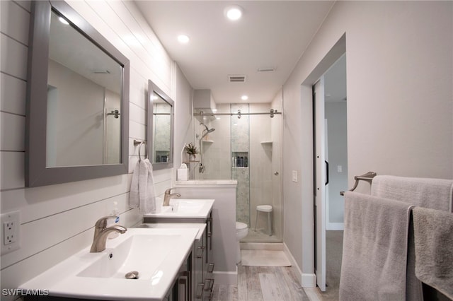 bathroom with a shower with shower door, toilet, wood-type flooring, and vanity