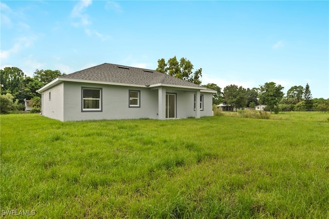 rear view of house featuring a yard