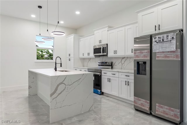 kitchen featuring a center island with sink, white cabinets, sink, hanging light fixtures, and stainless steel appliances