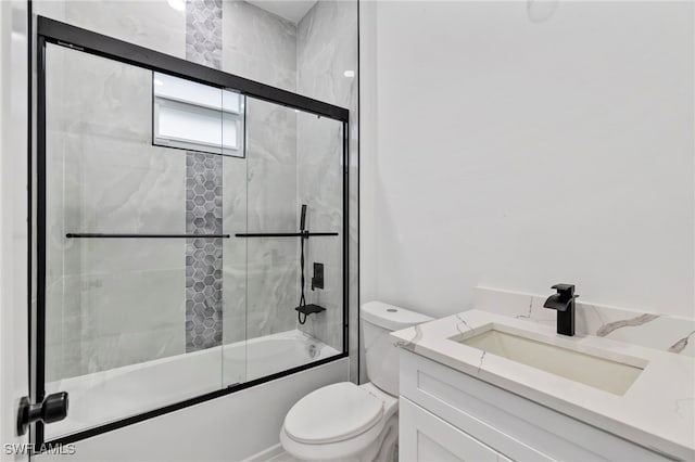 full bathroom with shower / bath combination with glass door, vanity, and toilet