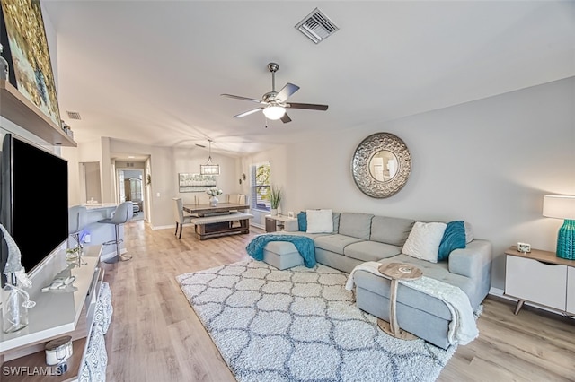 living room featuring ceiling fan and light hardwood / wood-style flooring