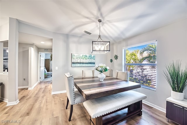 dining room with a notable chandelier and light wood-type flooring