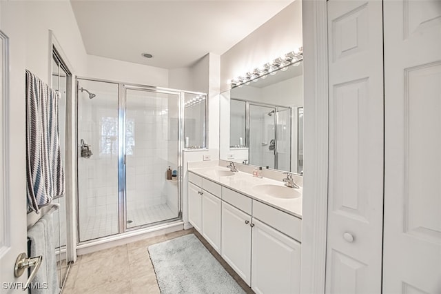 bathroom featuring tile patterned floors, a shower with door, and vanity