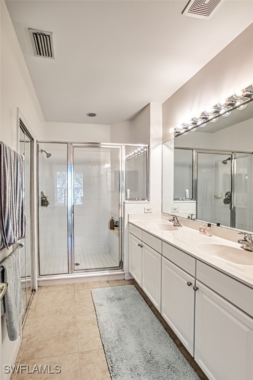 bathroom with tile patterned flooring, vanity, and walk in shower