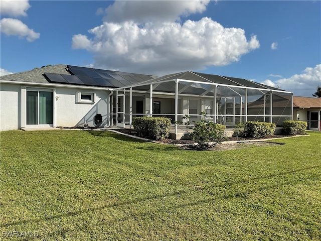 rear view of house with solar panels, a lanai, and a yard