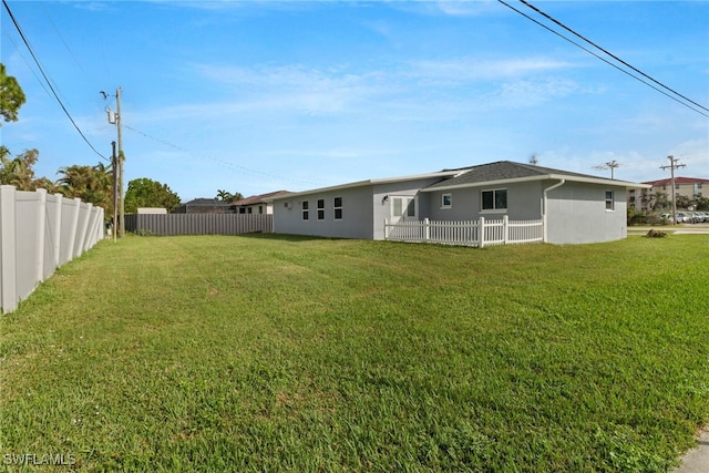 rear view of property featuring a lawn