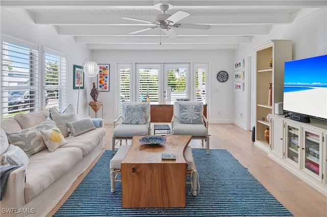 living room featuring beamed ceiling, plenty of natural light, and light hardwood / wood-style floors