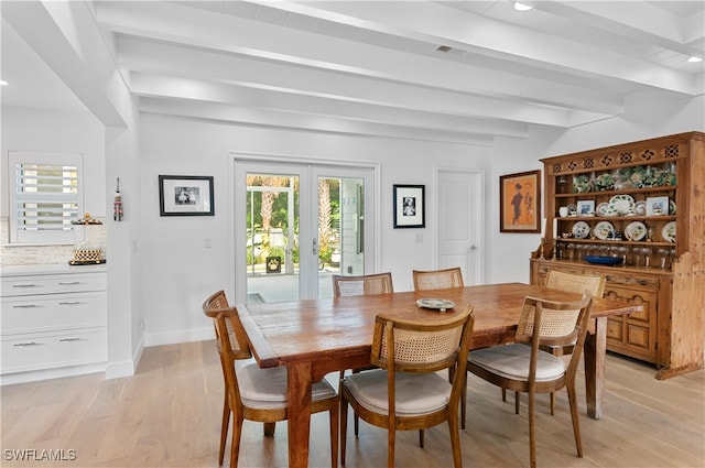 dining room with beamed ceiling and light hardwood / wood-style flooring