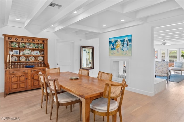 dining area featuring ceiling fan, beamed ceiling, and light hardwood / wood-style floors