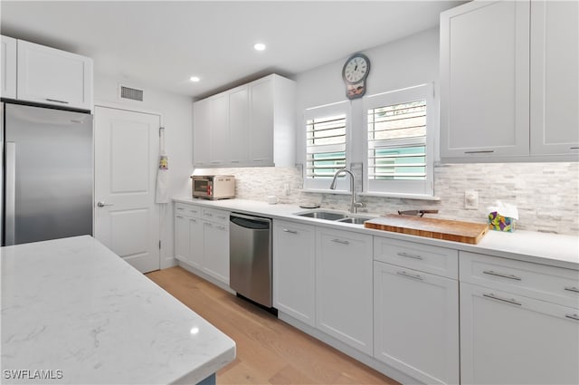 kitchen featuring white cabinets, stainless steel appliances, light hardwood / wood-style floors, and sink