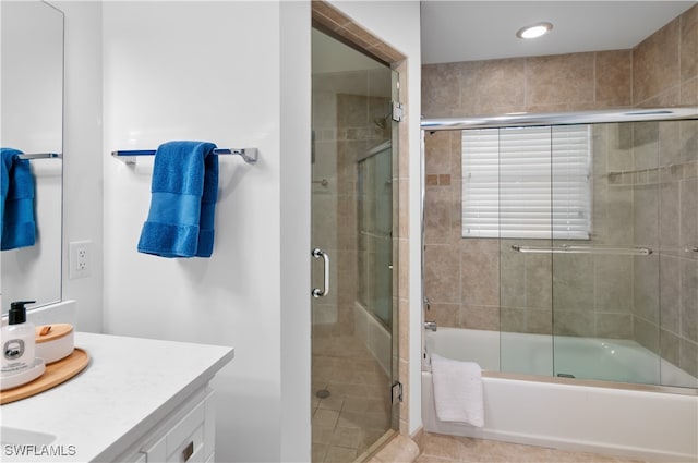 bathroom with tile patterned floors, vanity, and bath / shower combo with glass door