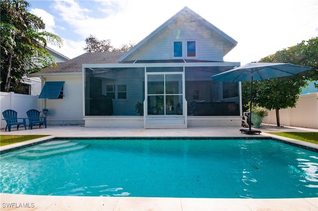 rear view of house featuring a patio, a fenced in pool, and a sunroom