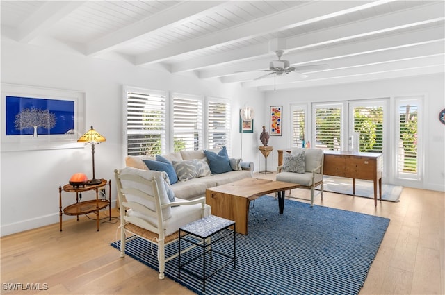 living room featuring beamed ceiling, plenty of natural light, light hardwood / wood-style floors, and ceiling fan