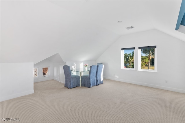 interior space featuring light carpet and vaulted ceiling