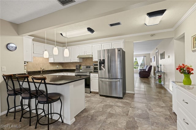 kitchen featuring a kitchen breakfast bar, stainless steel appliances, white cabinetry, and tasteful backsplash