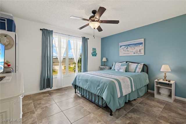 bedroom with tile patterned flooring, a textured ceiling, and ceiling fan