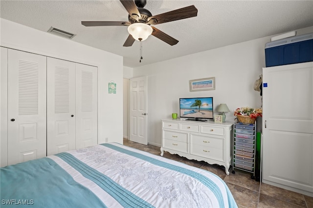 bedroom featuring ceiling fan, a textured ceiling, and a closet