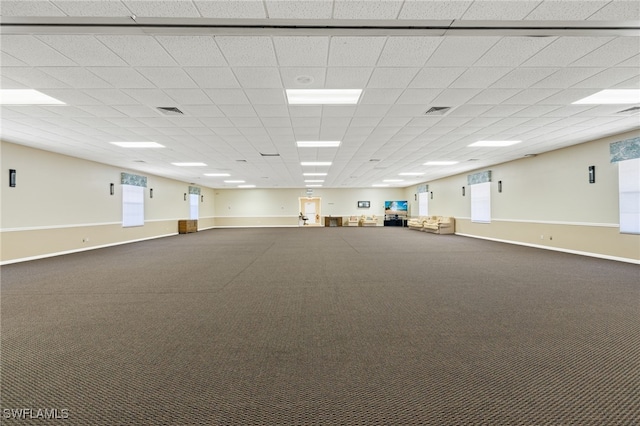 carpeted empty room with a drop ceiling