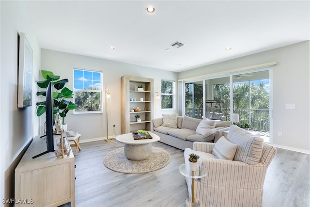 living room featuring a wealth of natural light and light hardwood / wood-style flooring