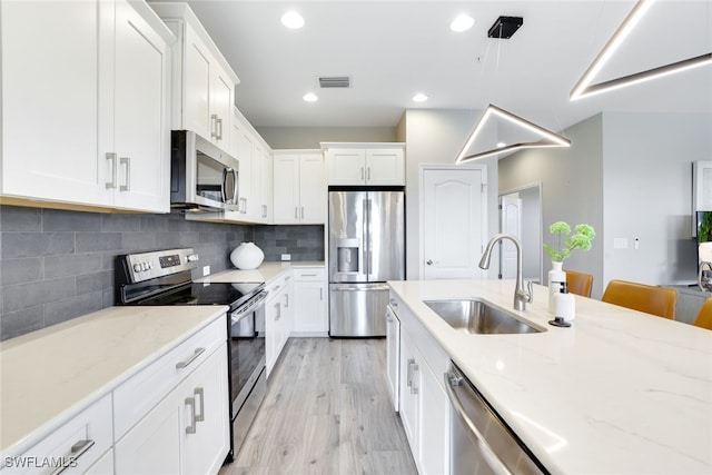 kitchen with white cabinets, sink, light wood-type flooring, and stainless steel appliances