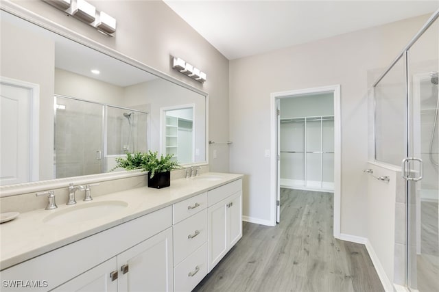 bathroom featuring vanity, wood-type flooring, and walk in shower