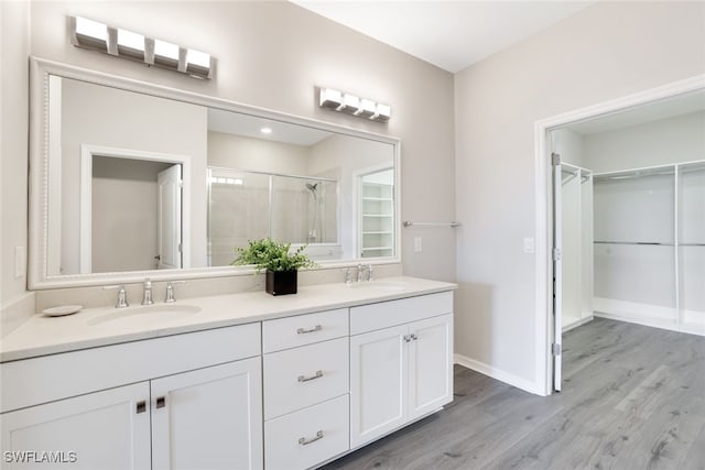 bathroom featuring vanity, an enclosed shower, and wood-type flooring