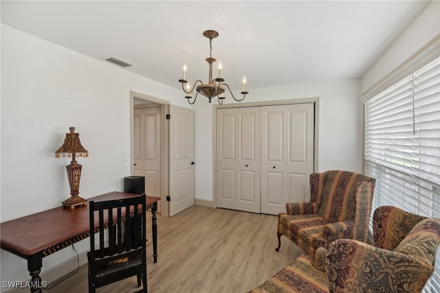 living area with a chandelier and light wood-type flooring