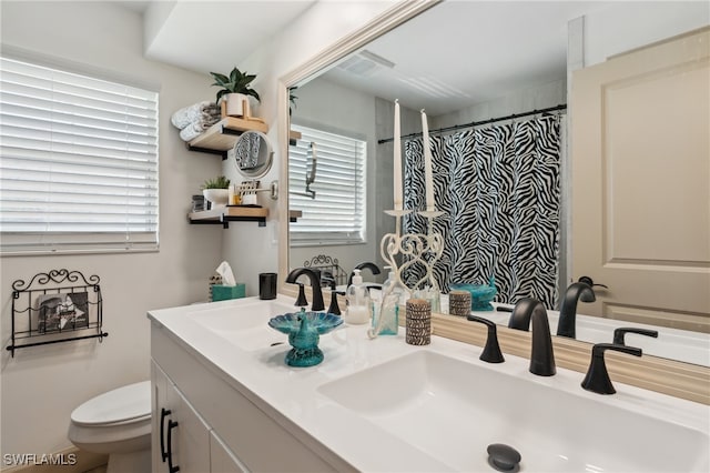 bathroom featuring vanity, curtained shower, and toilet