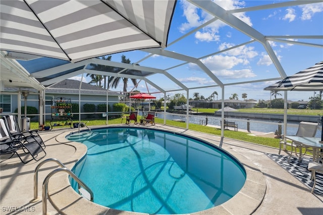 view of pool with glass enclosure, a water view, and a patio