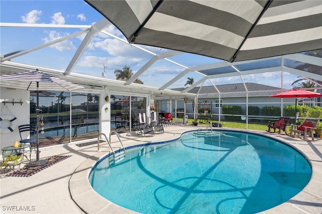 view of pool featuring glass enclosure and a patio area